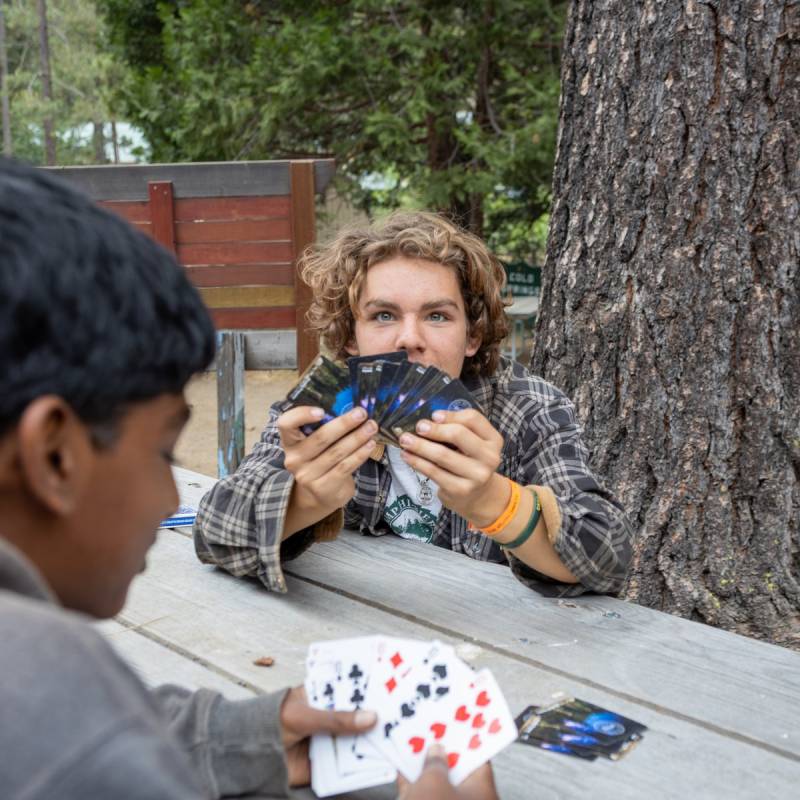 Scouts playing cards at a picnic table at Camp Hi-Sierra